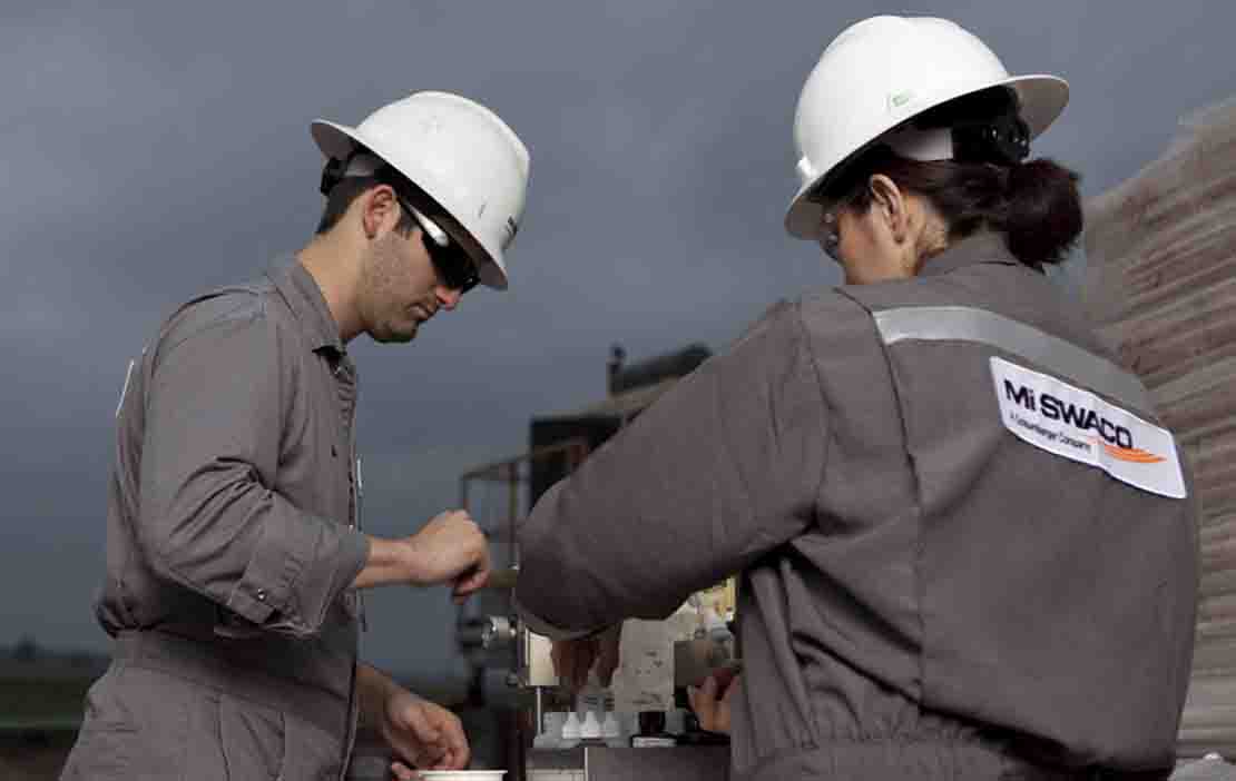 Two people outside in PPE.