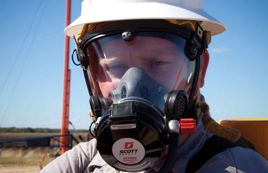 Worker in field wearing hydrogen sulfide mask protection