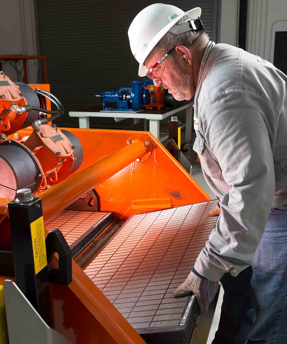A technician inserts a new DURAFLO screen into a shaker