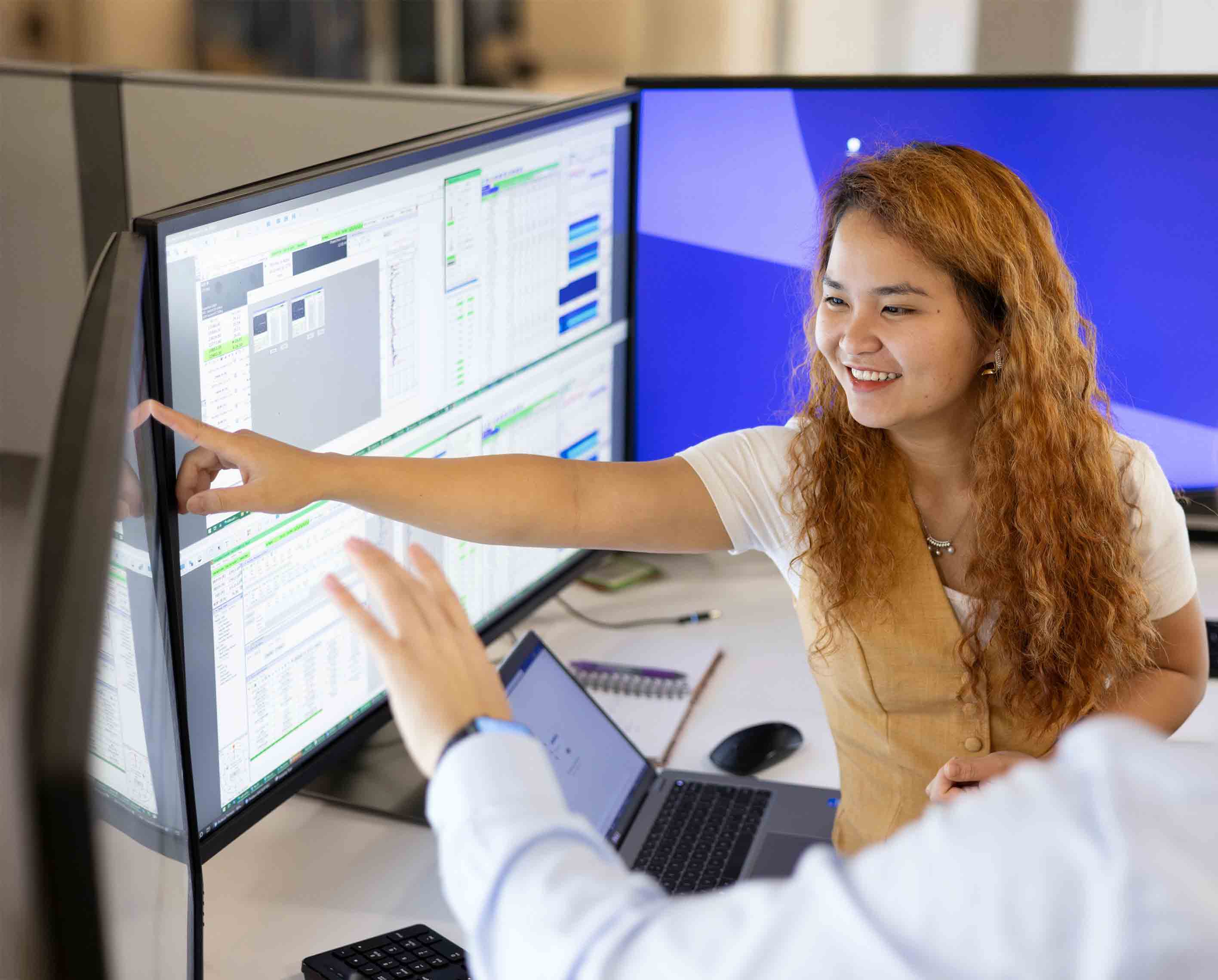 Image of people pointing at a monitor