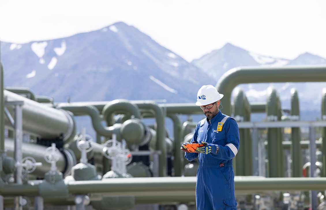 SLB Employee standing in front of a geothermal installation.