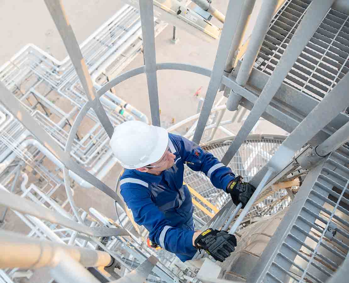 Schlumberger worker performing maintenance at a processing facility.
