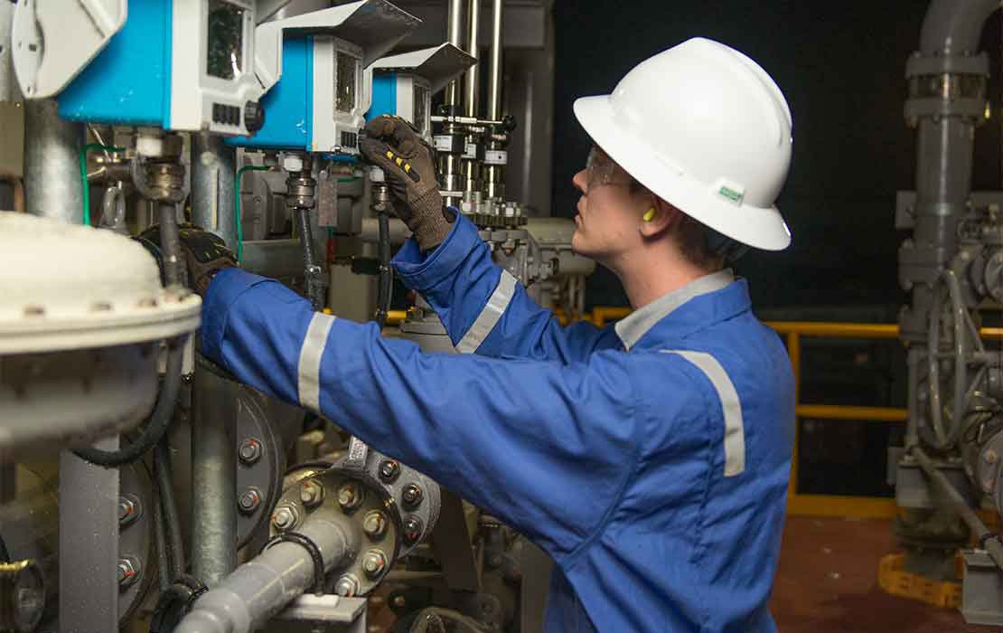 Man testing valve at oil treatment facility