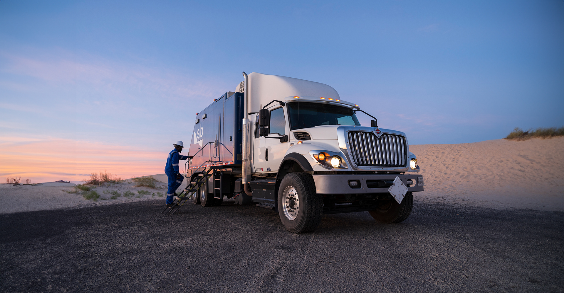 SLB wireline truck and employee in the field.