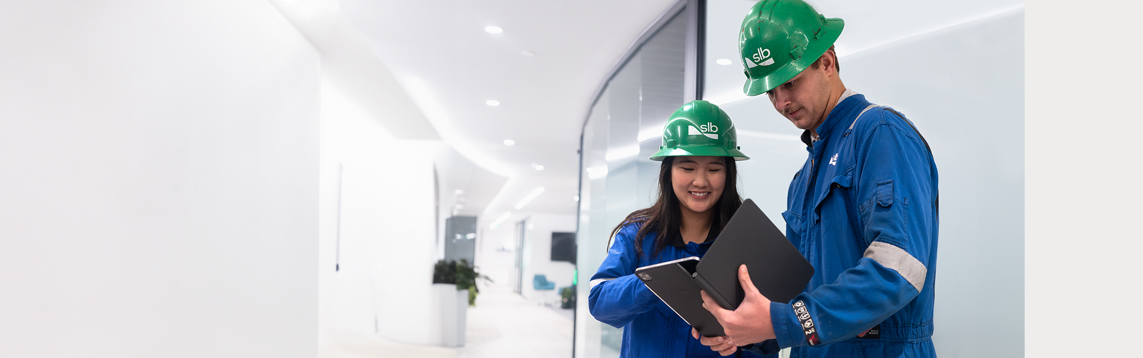 Two SLB operators discussing with each other while looking at a tablet