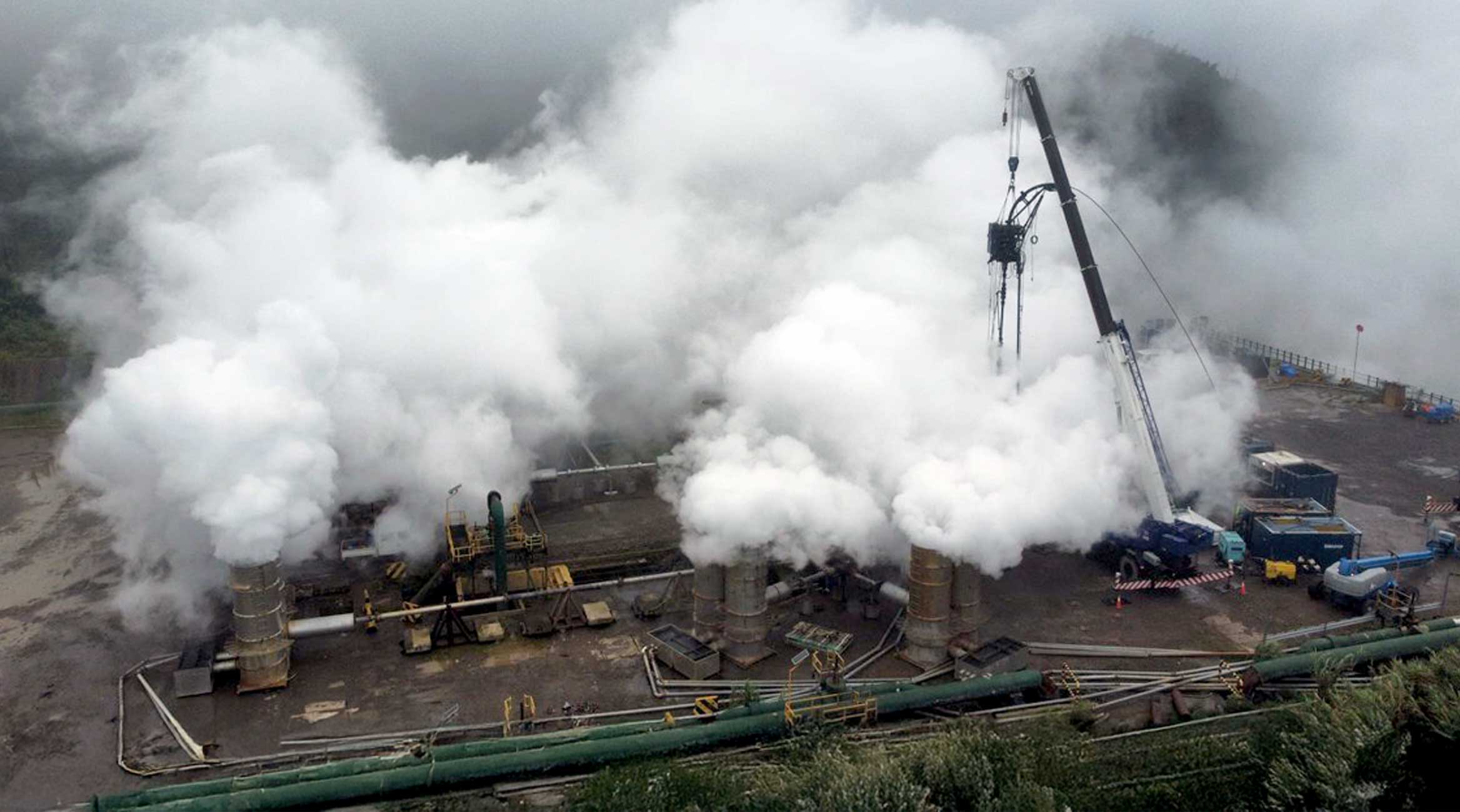 Photo shows CT rigged up at a geothermal site will clouds of steam all around.