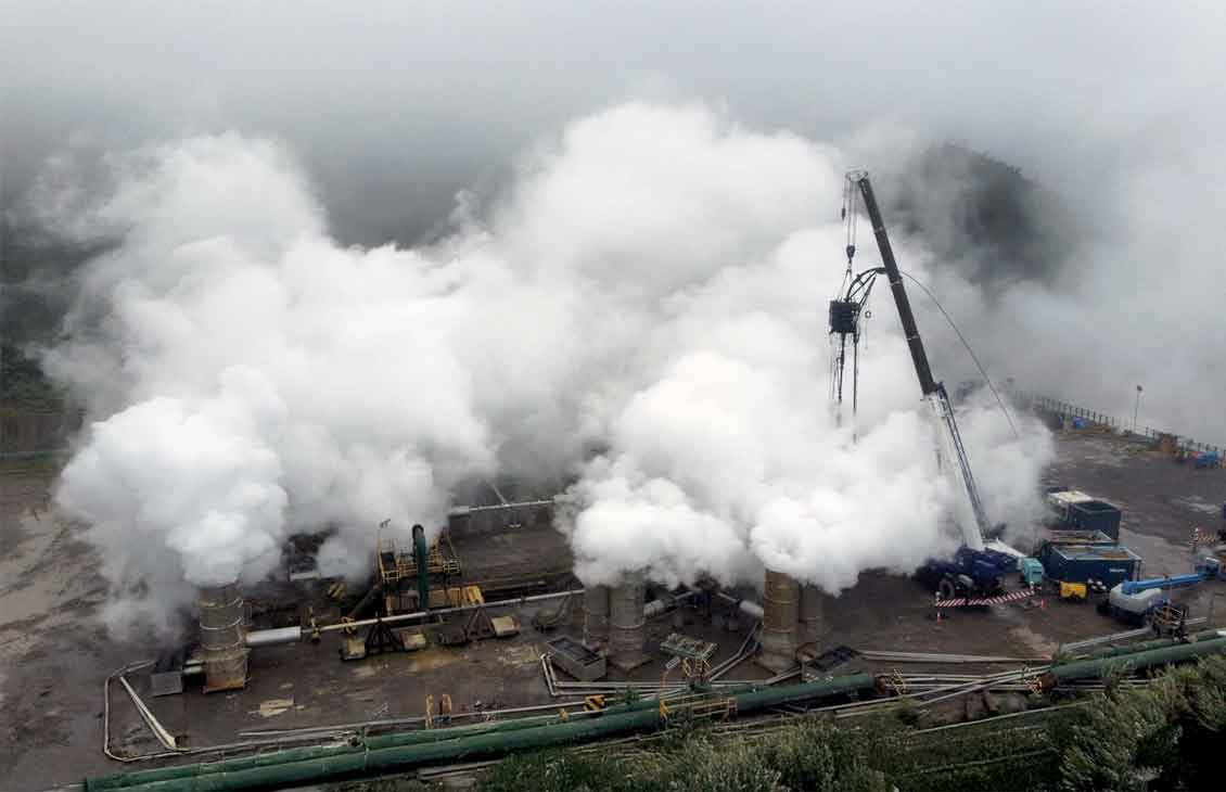 Photo shows CT rigged up at a geothermal site will clouds of steam all around.