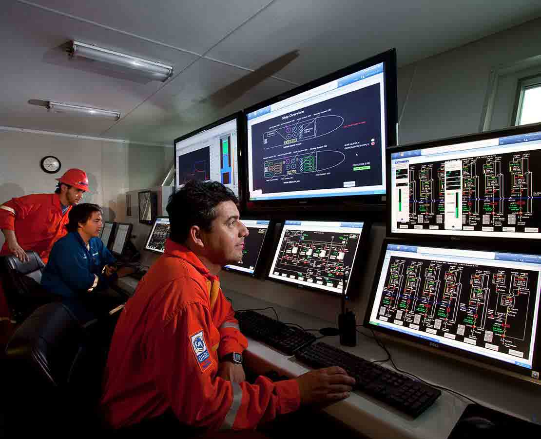 Schlumberger Workers in a DeepSTIM stimulation vessel Viewing Data on Monitors