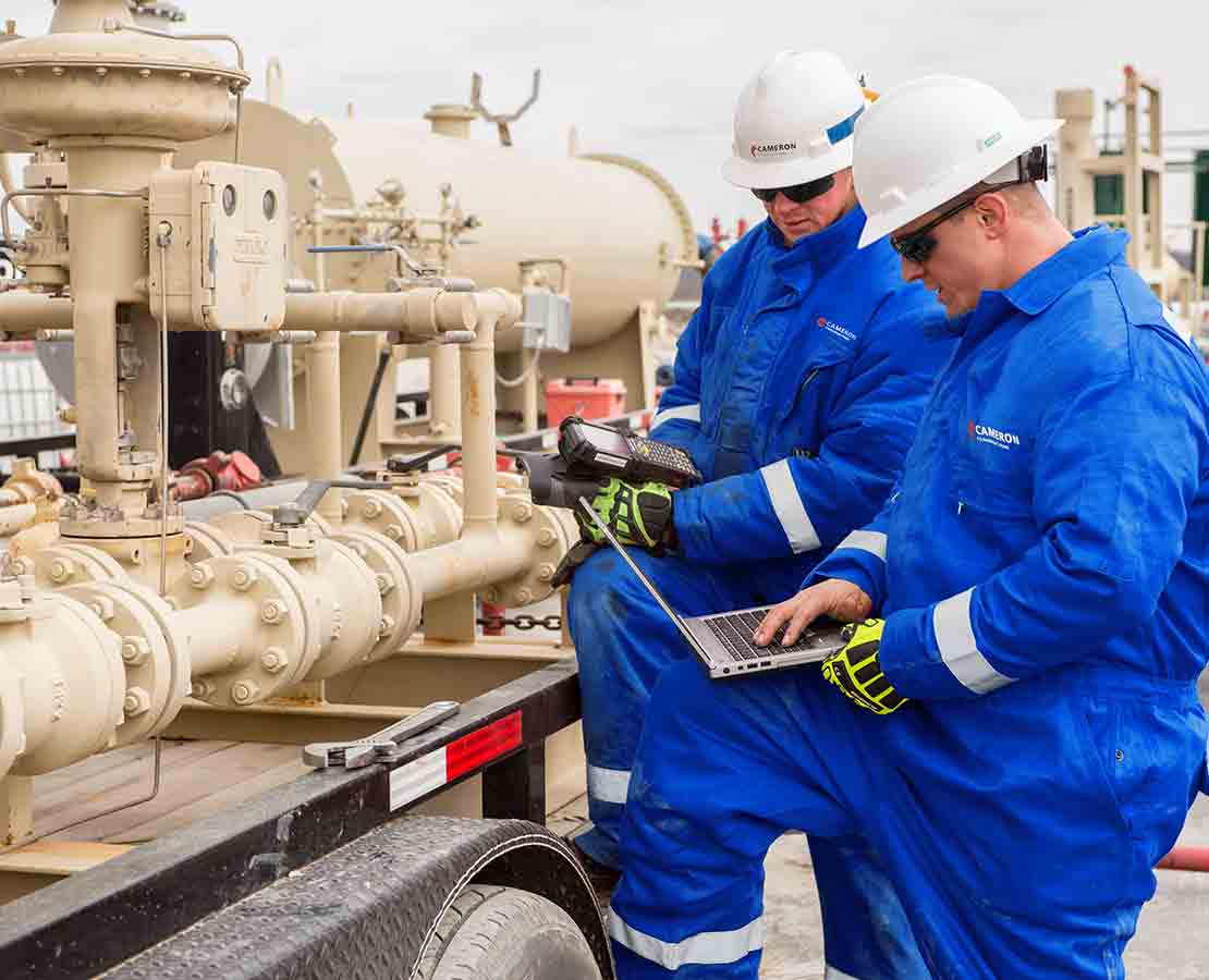 Two Schlumberger Workers Inspecting the Flowback Well Cleanup Equipment