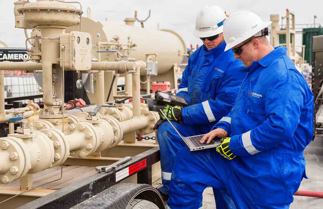 Two Schlumberger Workers Inspecting the Flowback Well Cleanup Equipment