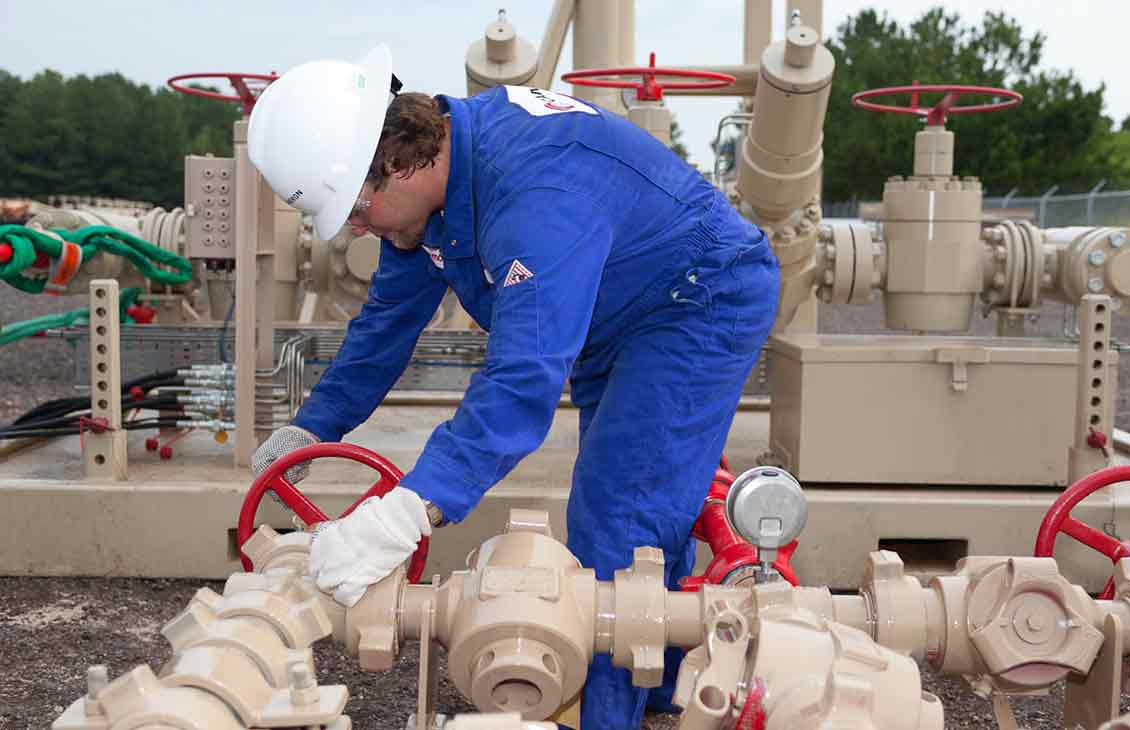 Cameron Worker Performing Maintenance Check on Plug Valve Choke Manifold in the Field