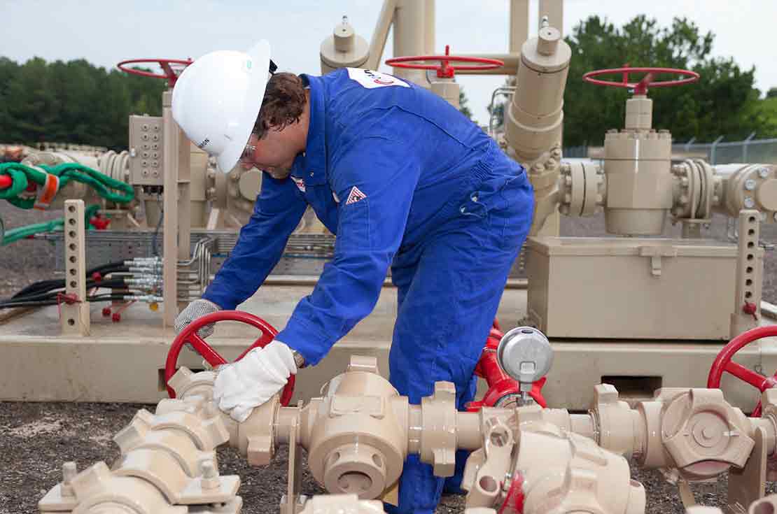 Cameron Worker Performing Maintenance Check on Plug Valve Choke Manifold in the Field