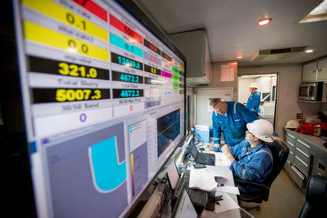 Fracturing cabin with two Schlumberger employees discussing a fracturing job.