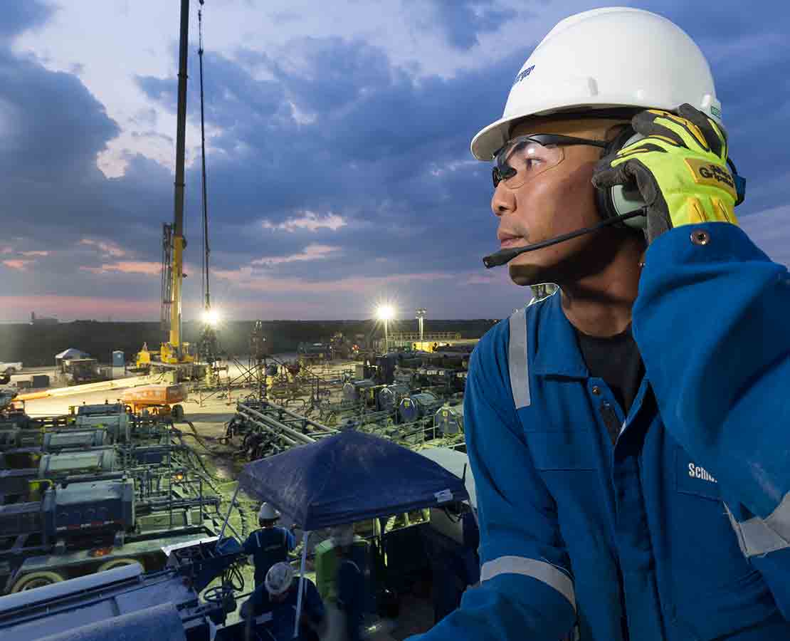 Schlumberger worker looking at the rigsite during night operations.