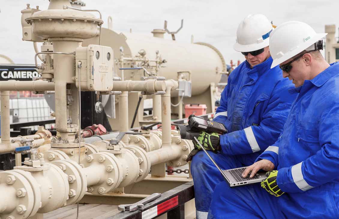 Image of Cameron technicians using digital monitoring, control, and automation during wellsite operations.