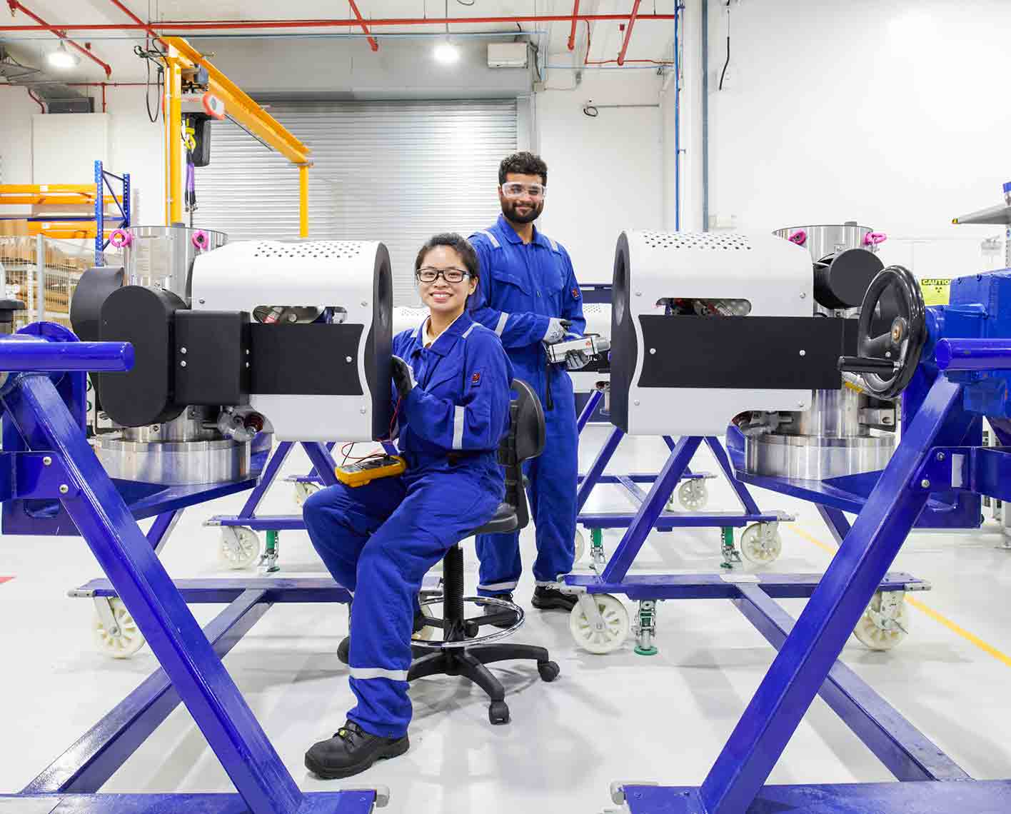 Two SLB operators inspecting a Vx Spectra in a manufacturing facility