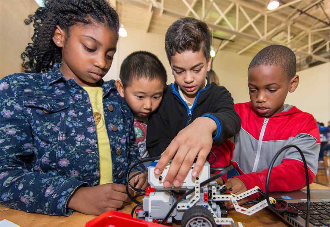 Group of primary school students with a robotic toy vehicle.