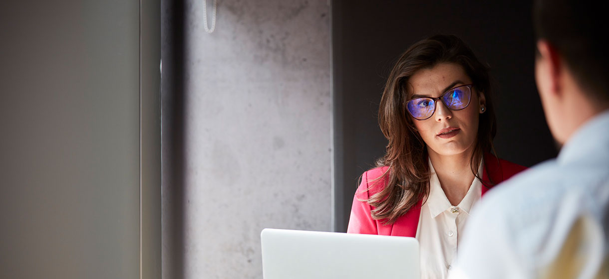 Image of two people talking at the office.