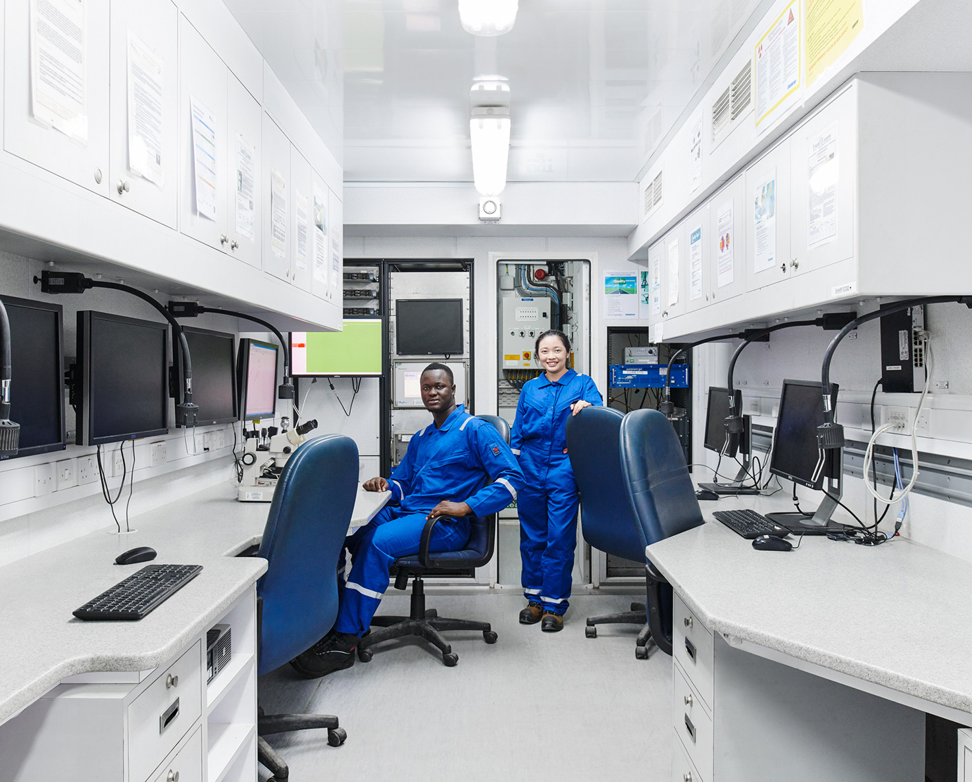 Two SLB employees in front of computers in a lab