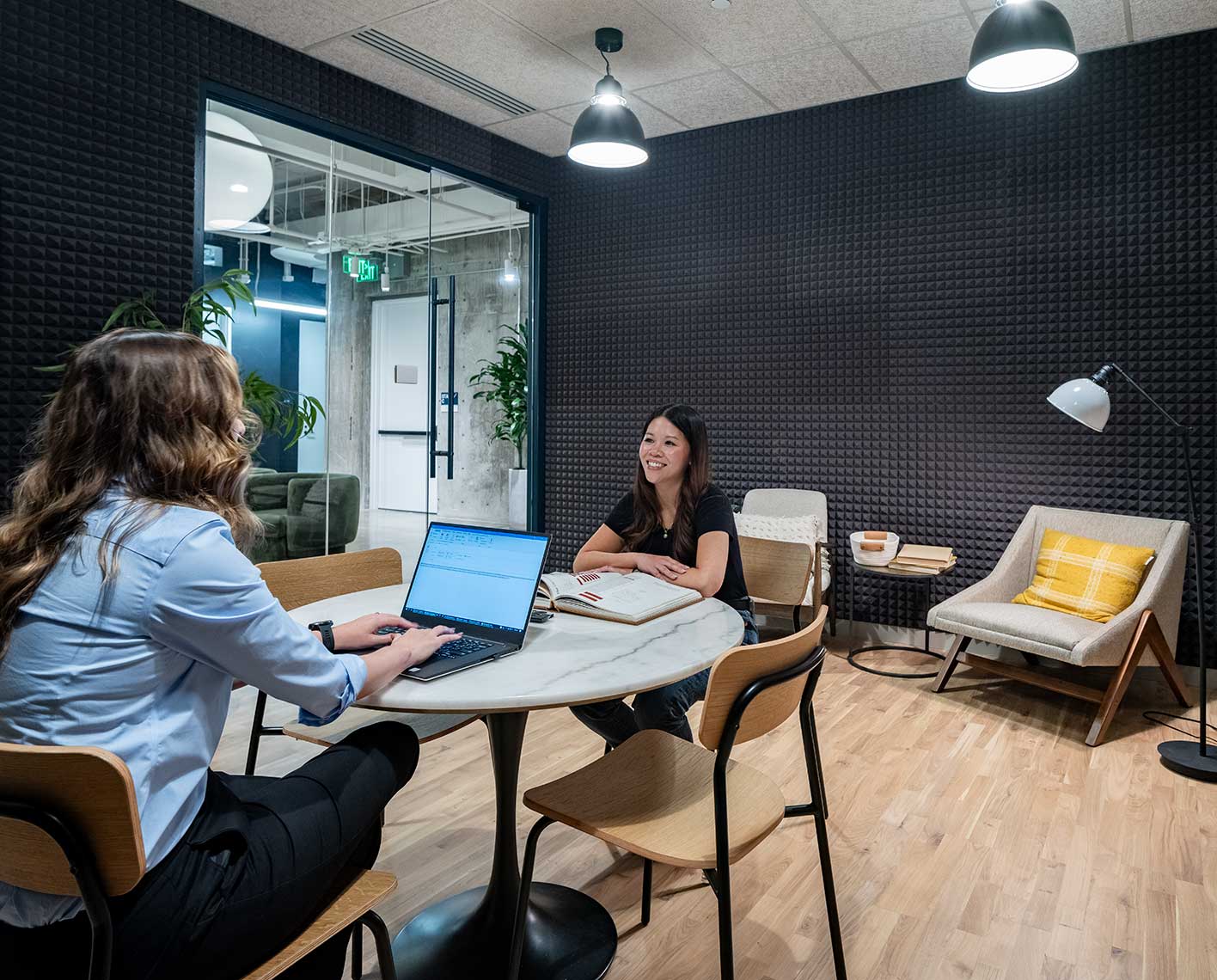 two employees sitting at a table facing across from each other