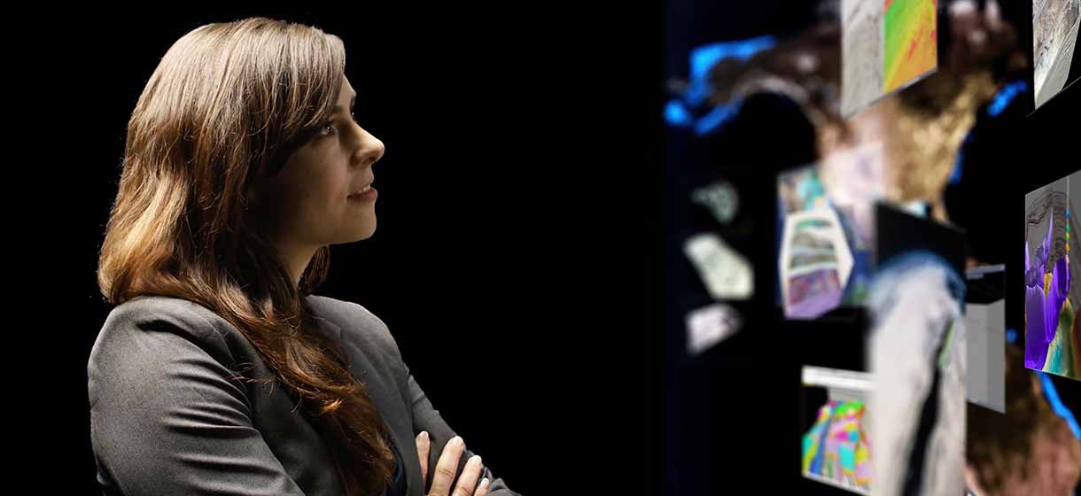 Woman with crossed arms looking at digital representations of content.