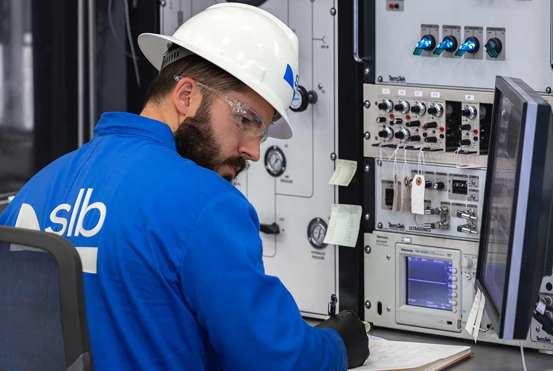 Schlumberger worker in the lab performing core analysis as part of the geomechanics services.