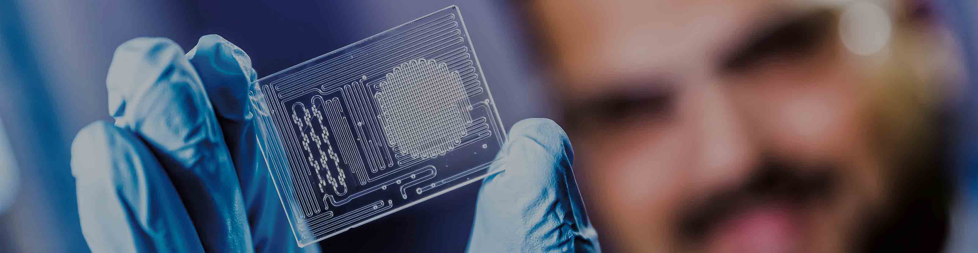 Schlumberger worker holding Maze microfluidic SARA analysis technology in his hand.