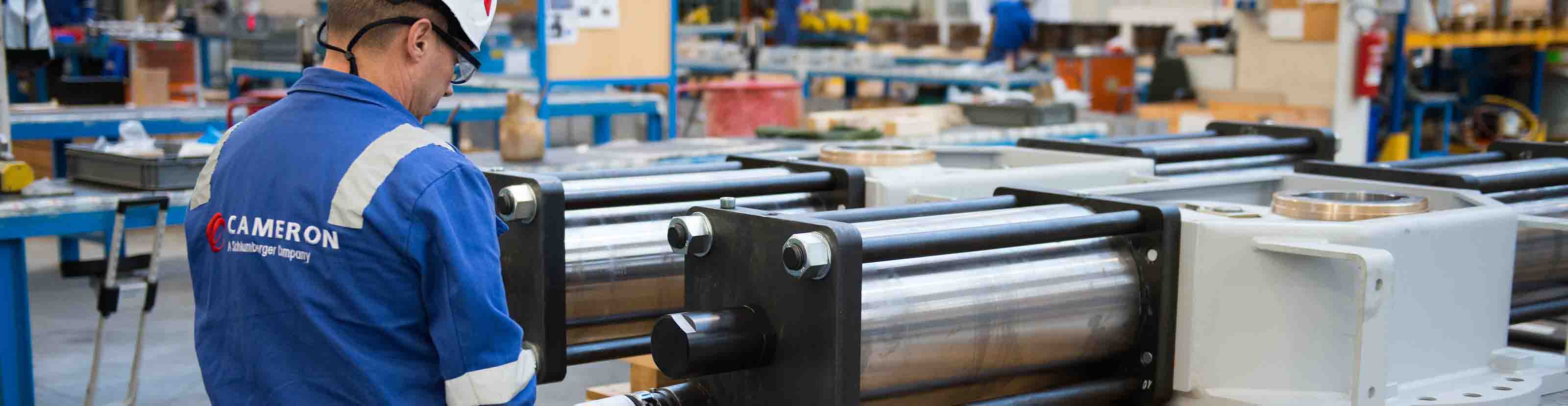 Cameron employee working on LEDEEN actuator in warehouse.