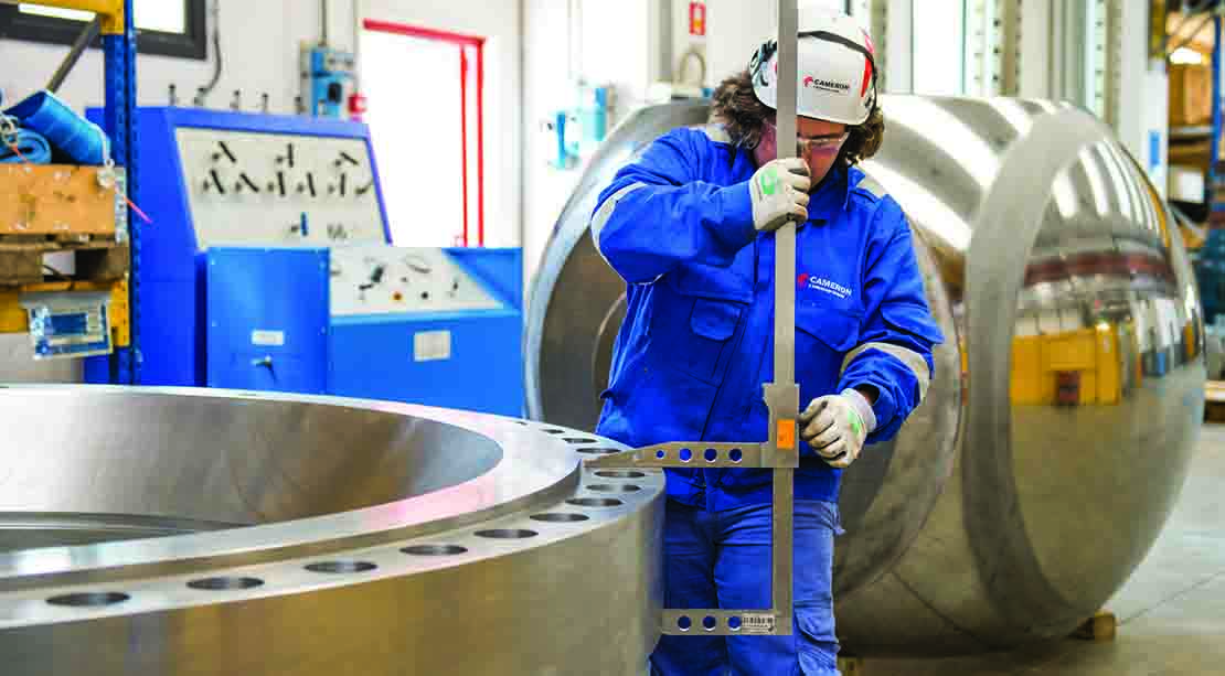 Cameron employee conducting quality control on subsea valve in facility.