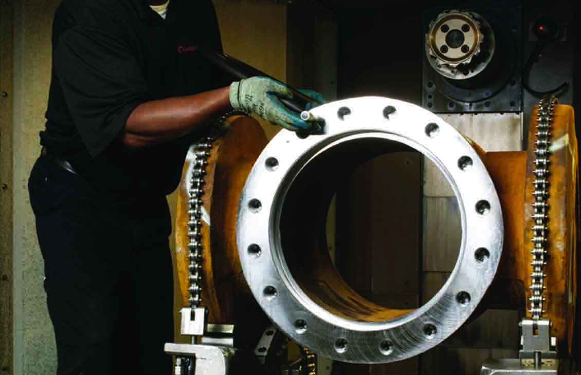 Plug valve being maintenanced by Cameron employee inside the shop.