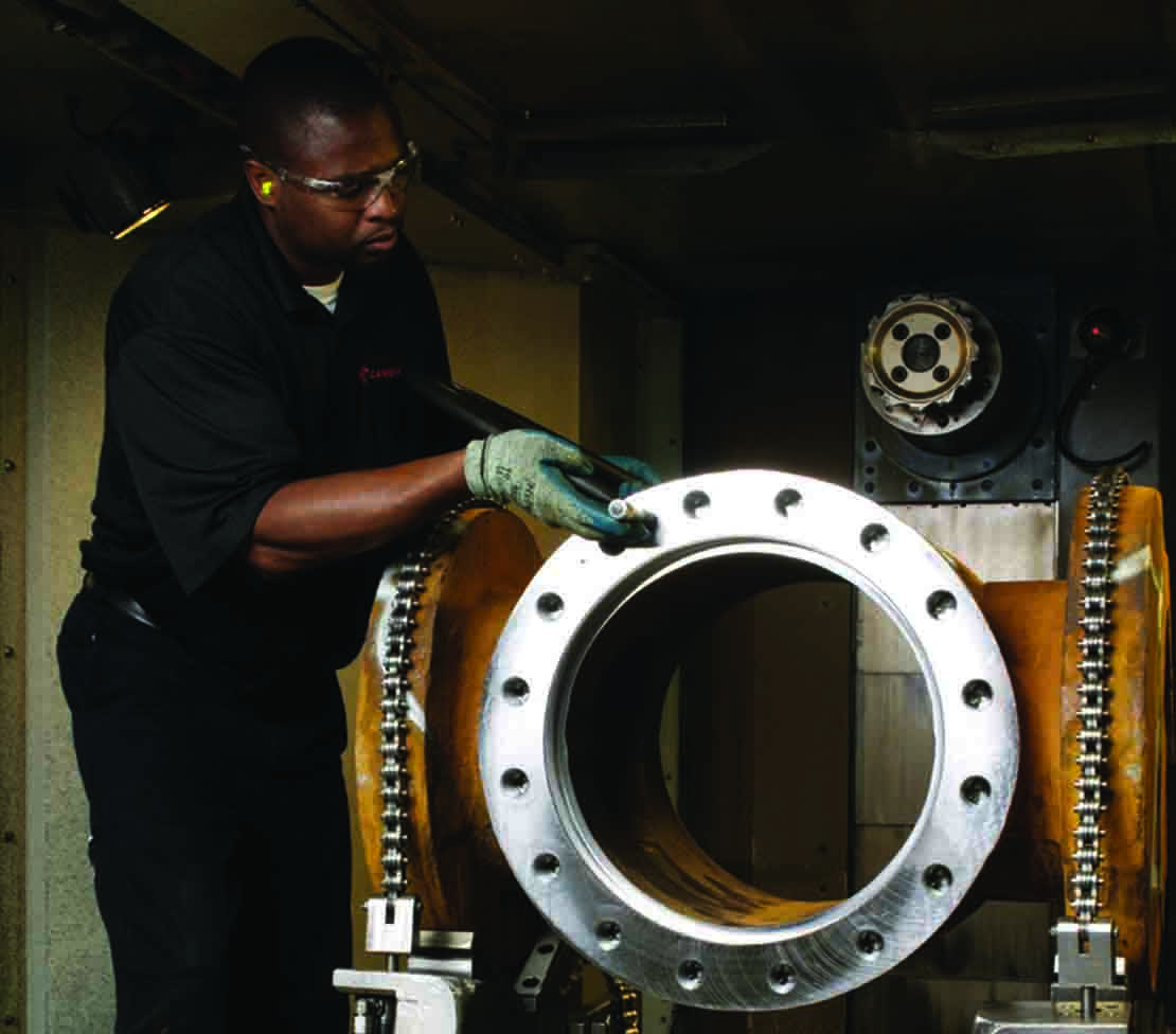 Plug valve being maintenanced by Cameron employee inside the shop.