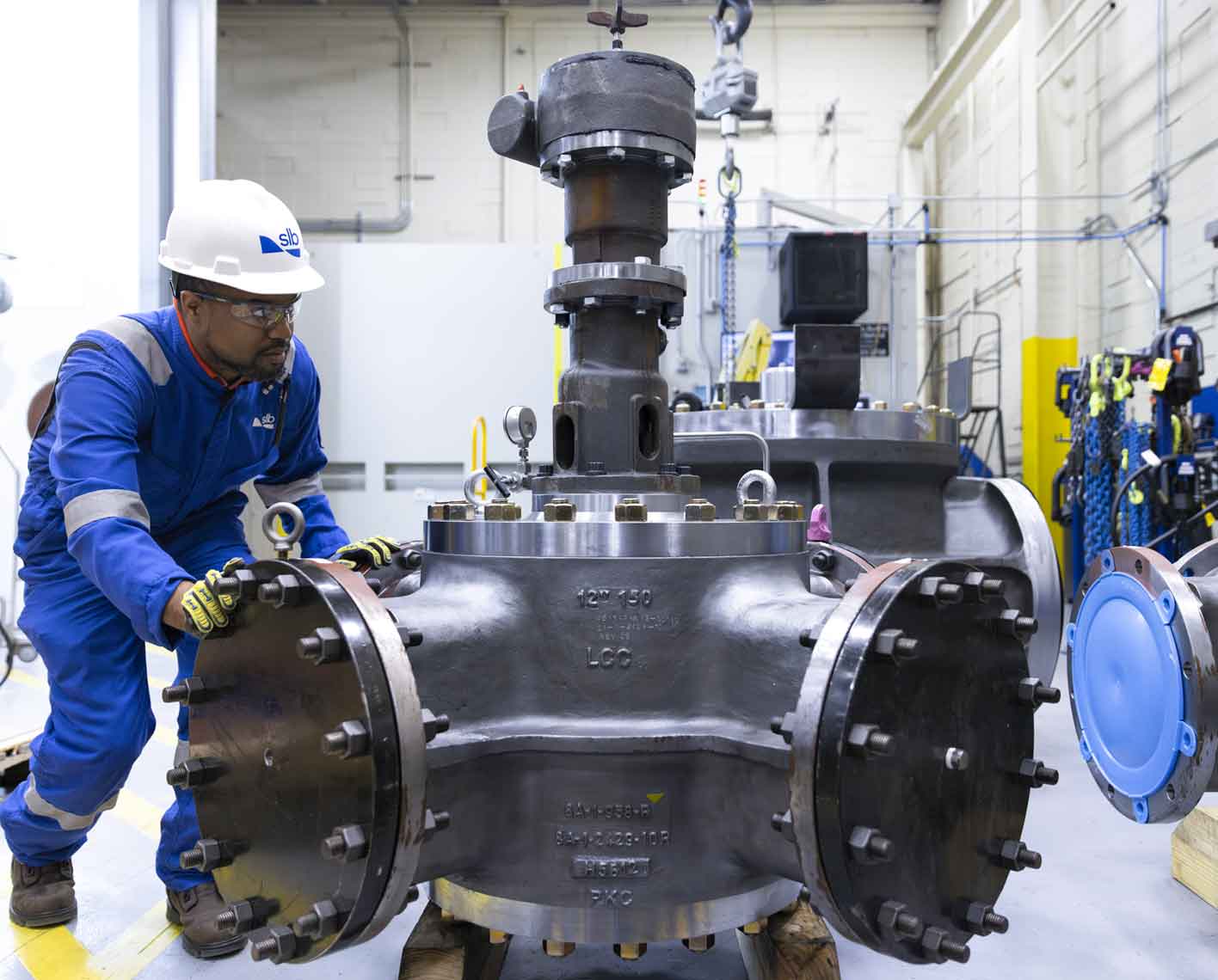 Photo of a man working with a large valve in a warehouse