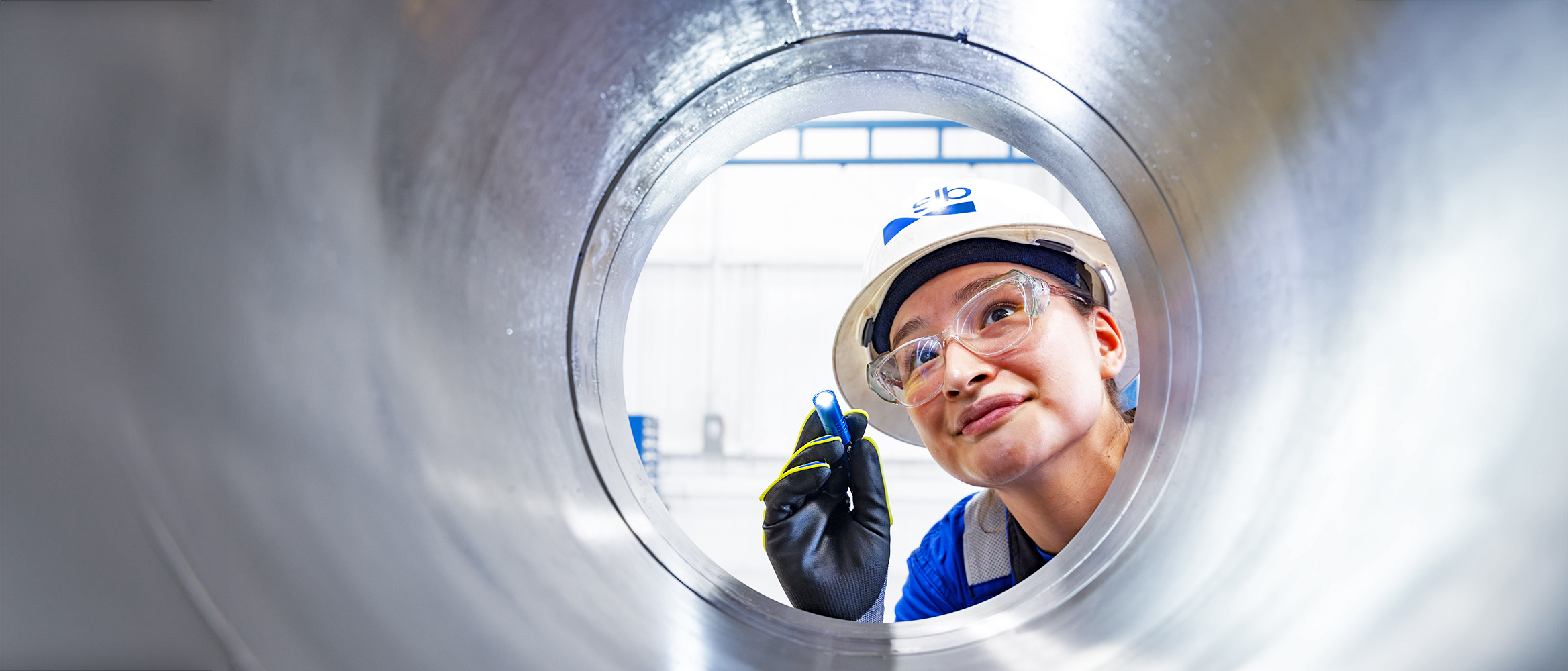 Photo of a person examining a pipe.